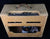 Vintage-style guitar amplifier with a textured beige exterior on a black background